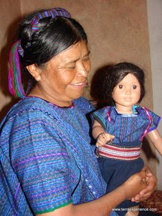 an older woman holding a doll in her hands