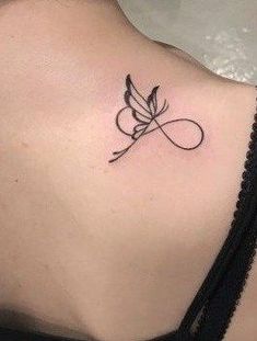 the back of a woman's shoulder with a small tattoo on her left side