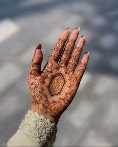 a woman's hand with henna tattoos on it