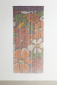 an orange and green painting hanging on the wall next to a wooden table with a vase