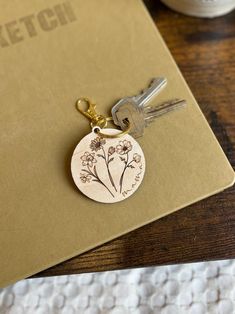 a wooden keychain with a flower engraved on it