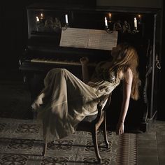 a woman sitting in front of a piano