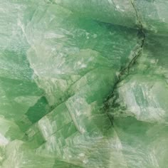 an abstract photograph of green and white rocks with small cracks in the rock, as if they were ice crystals