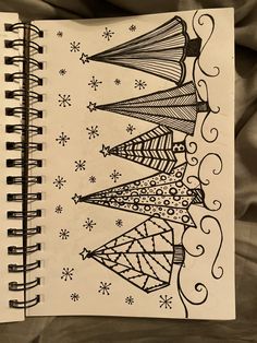 a notebook with some drawings on it and snowflakes in the backgroud