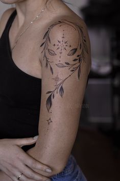 a woman with a tattoo on her arm and shoulder is looking down at the camera