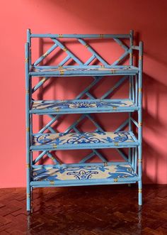 a blue and white shelf against a pink wall