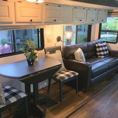 a living area with couches, table and windows