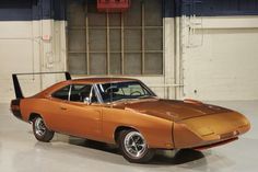 an orange muscle car parked in a garage