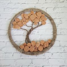 a tree made out of wine corks on a white brick wall with a circular frame