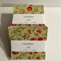 three boxes are stacked on top of each other with floral designs and words written on them