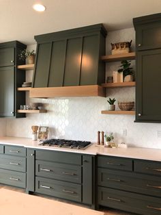 a kitchen with green cabinets and white counter tops, along with open shelving above the stove