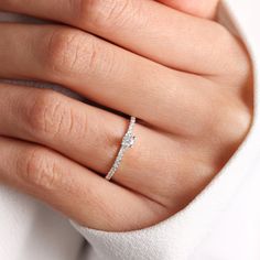 a woman's hand with a diamond ring on it