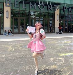 a woman dressed in pink is walking down the street