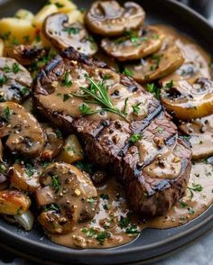 steak with mushrooms, onions and gravy on a plate