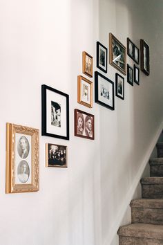 a staircase with pictures on the wall and framed photos hanging on the wall next to it