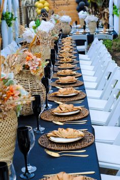 a long table is set up with place settings for an outdoor dinner or party event