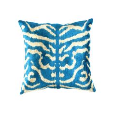 a blue and white pillow with an animal print on the front, sitting against a white background