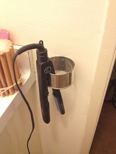 an electric hair dryer is hanging on the wall