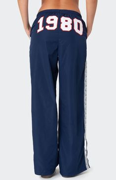 These Edikted 1980 Nylon Track Pants offer both style and comfort, making them perfect for a sporty yet fashionable look. They're ideal for any activity, ensuring you feel comfortable and confident throughout your entire day. Track pantsLace stripe detailingSlitted hemAdjustable waist tieEmbroidered graphic textPolyesterModel wears size SModel height is 5'8Item care: Machine wash at maximum 30C, wash with similar colors, do not bleach, do not tumble dry, iron at a maximum of 110C, do not dry clean. Edikted Womens 1980 Nylon Track Pants - Blue size Large Sweatpants With Words On Back, Sporty Fits, Cool Sweatpants, White Track Pants, Nylon Track Pants, Vintage Sweatpants, Graphic Sweatpants, Hip Hop Pants, Birthday Fits