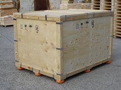 a large wooden crate sitting on top of a cement floor next to pallets of wood