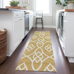 a kitchen with white cabinets and yellow rugs on the wooden floor next to an oven