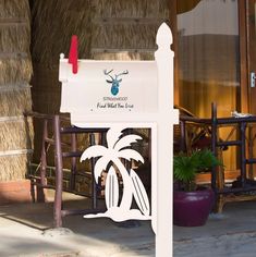 a white mailbox sitting next to a palm tree