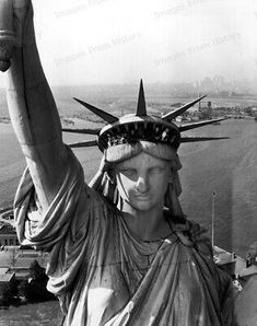 the statue of liberty is wearing a crown and holding her hands up in front of her head