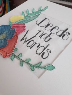 a close up of a piece of paper with words on it and flowers in the middle