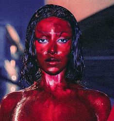 a woman with red paint on her face and body