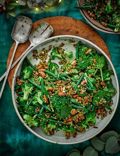 a white bowl filled with green vegetables and nuts