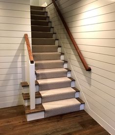 a set of stairs leading up to the second floor in a house with white walls and wood floors