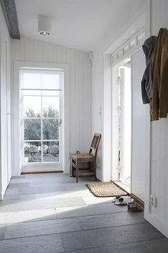 an empty room with white walls and wood flooring on the side, there is a wooden bench in the middle