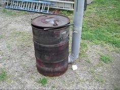 an old barrel sitting next to a metal pole