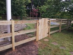 the fence is made out of wood and has an animal enclosure on top of it