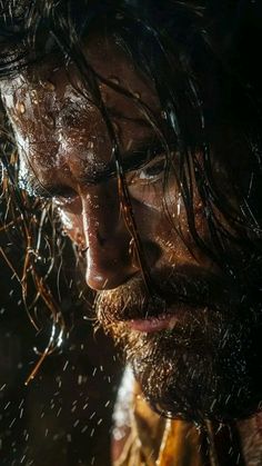 a man with wet hair and beard standing in the rain