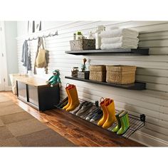 the shoes are lined up on the shelf next to the towel rack in the hallway