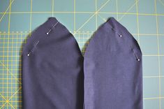 two pieces of blue fabric sitting on top of a cutting board