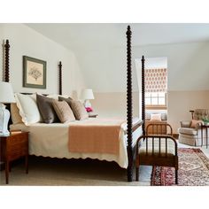 a bedroom with four post bed, chair and rug