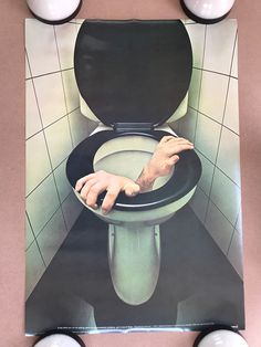 a toilet with the lid up and hands on it