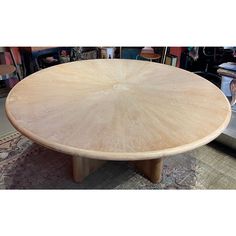 a round wooden table sitting on top of a rug