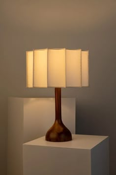 a table lamp sitting on top of a white block with three lamps in it's center