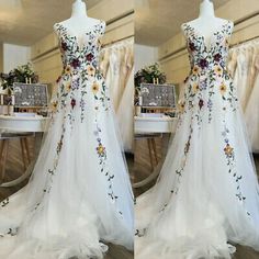 two pictures of a wedding dress with flowers on the front and back, in different angles