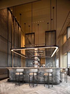 an elegant bar with marble counter tops and barstools in the middle of it