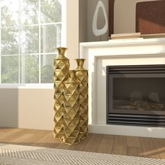 two gold vases sitting next to each other in front of a fire place with a window