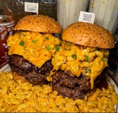 two hamburgers with macaroni and cheese on them