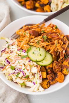 two bowls filled with bbq chicken and coleslaw slaw next to cucumbers