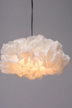 a white flower light hanging from a ceiling