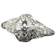 an antique style diamond ring with filigrees on the sides and round brilliant cut diamonds