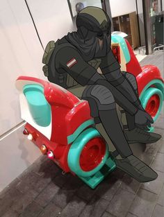 a cartoon character sitting on top of a red and green toy car in a building