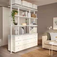 a living room filled with furniture and a white book shelf on top of a wooden floor